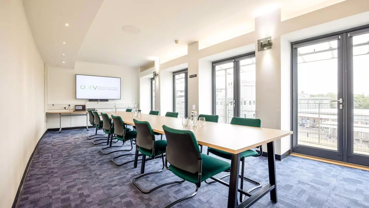 Meeting room with one long table in the center of the room with chairs around the outside