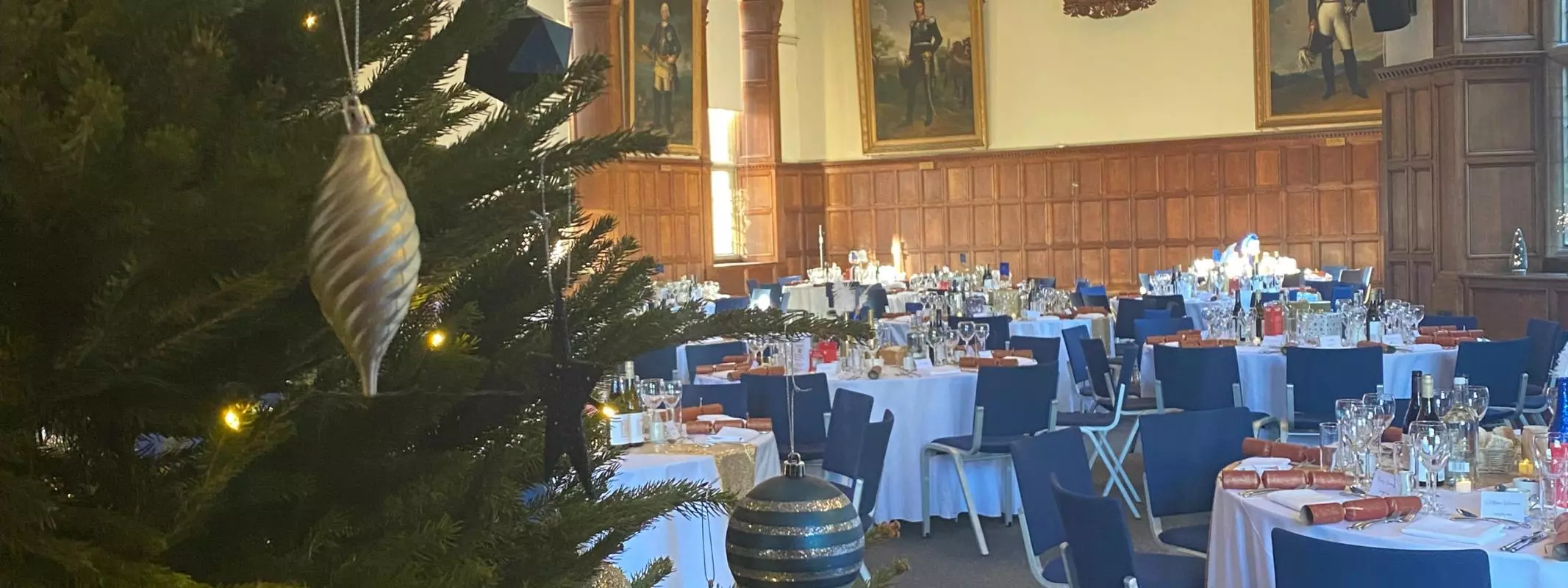 A festive party at the Examination Schools in Oxford, with a christmas tree in the foreground